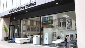 A modern, well-appointed athletic therapy clinic in downtown Calgary, Alberta. The exterior features a clean, contemporary facade with large windows and a prominent signage. The lobby is bright and inviting, with comfortable seating, informative posters, and a reception desk. In the treatment rooms, state-of-the-art equipment like massage tables, ultrasound machines, and exercise equipment are neatly arranged. Skilled therapists in professional attire are seen tending to patients, providing personalized care and guidance. The overall atmosphere conveys a sense of professionalism, expertise, and a commitment to helping athletes and active individuals recover and perform at their best.