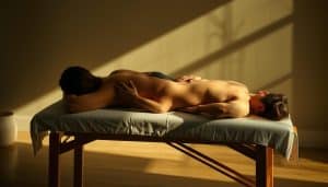 A serene, dimly lit studio setting with an athletic figure lying on a massage table, receiving a deep tissue massage. The masseuse's skilled hands carefully manipulate the muscles and joints, promoting circulation and flexibility. Soft, natural lighting casts an ethereal glow, while the background features calming, abstract textures that evoke a sense of renewal and restoration. The scene conveys a therapeutic atmosphere, highlighting the holistic approach to injury recovery through manual therapy techniques.